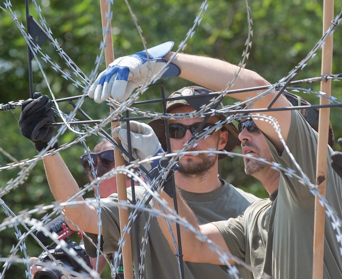 Zwei Soldaten hantieren an einem Stacheldrahtzaun. picture alliance / Photoshot